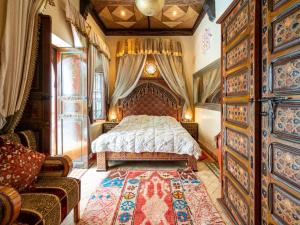 een slaapkamer met een bed, een bank en een tapijt bij Riad Hikaya in Marrakesh