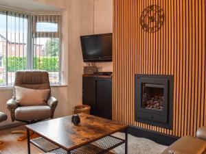 a living room with a fireplace and a tv at Gatesgarth in Longton