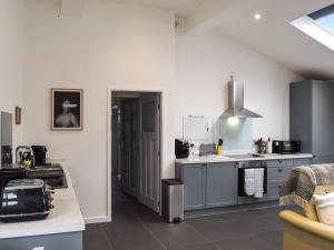 a kitchen with gray cabinets and a stove top oven at Gatesgarth in Longton