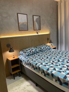 Schlafzimmer mit einem Bett mit einer blauen und weißen Bettdecke in der Unterkunft The best ap in Rio de Janeiro
