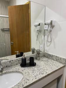 eine Badezimmertheke mit einem Waschbecken und einem Spiegel in der Unterkunft The best ap in Rio de Janeiro