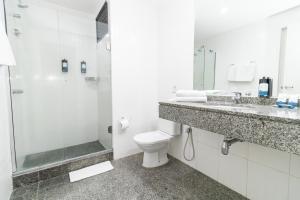 a bathroom with a shower and a toilet and a sink at Slaviero Hotel Curitiba Shopping in Curitiba