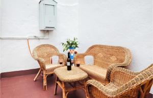 eine Gruppe Korbstühle und ein Tisch mit einer Vase in der Unterkunft Lovely Home In Olvera With Wi-fi in Olvera