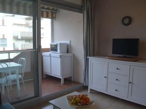 a living room with a television and a table with a bowl of fruit at Appartement Saint-Raphaël, 2 pièces, 4 personnes - FR-1-226A-23 in Saint-Raphaël