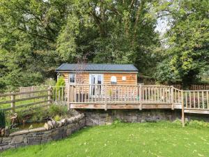 a tiny house on a bridge over a yard at Chateau Petit in Caersws