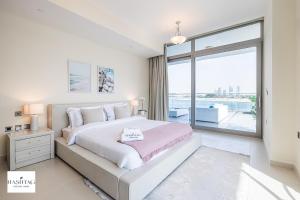 - une chambre avec un grand lit et une grande fenêtre dans l'établissement 2BDR apartment with full sea view and Dubai Marina view Azure Residences, à Dubaï