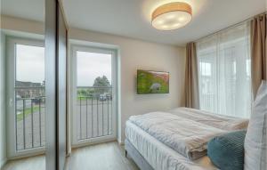 een slaapkamer met een bed en een groot raam bij Nice Apartment In Nordstrand With Kitchen in Nordstrand