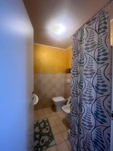 uma casa de banho com um WC e uma cortina de chuveiro em Zagara room em Padule