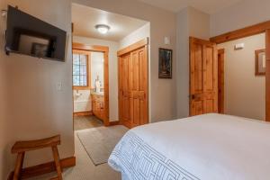 ein Schlafzimmer mit einem weißen Bett und ein Badezimmer in der Unterkunft Cabins 1 in Mammoth Lakes