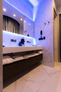 uma casa de banho com um lavatório e um balcão com toalhas em Tsarsky Hotel em Kiev