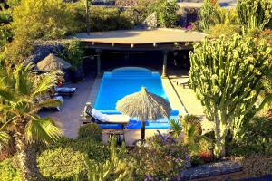 einen Blick über einen Pool mit Sonnenschirm in der Unterkunft Casa La Concha in La Asomada