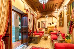 a living room with red couches and a fireplace at Riad Hikaya in Marrakech