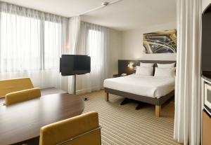 ヴェリジー・ヴィラクブレーにあるB&B HOTEL Vélizy Estのベッドとテーブルが備わるホテルルームです。