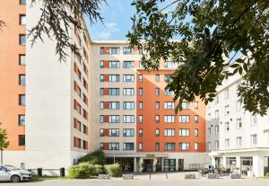 un edificio de apartamentos frente a un aparcamiento en B&B HOTEL Vélizy Est, en Vélizy-Villacoublay