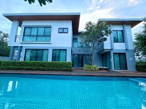 a house with a swimming pool in front of a house at Chic Villa 6 in Chiang Mai