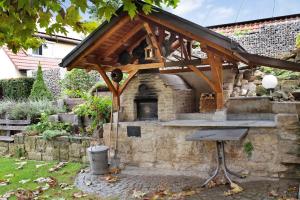 un horno de piedra en un jardín con techo de madera en Ferienwohnung Atelier, en Bad Bellingen