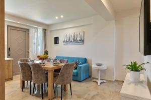 comedor con mesa y sofá azul en Modern Family apartment Ewa with pool, dining area on Crete coast, en Stavromenos