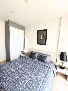 a bedroom with a large bed with a blue comforter at Condominium Phuket Downtown in Ban Rangeng