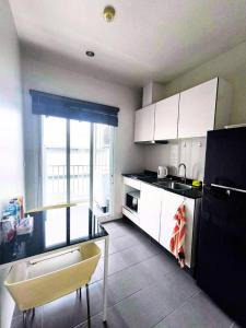 a kitchen with white cabinets and a sink and a window at Condominium Phuket Downtown in Ban Rangeng
