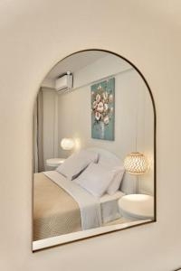 a bedroom with a large mirror on a white wall at Modern Family apartment Ewa with pool, dining area on Crete coast in Stavromenos