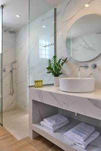 a white bathroom with a sink and a mirror at Modern Family apartment Ewa with pool, dining area on Crete coast in Stavromenos