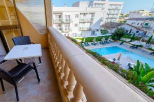 - un balcon avec une table et une piscine dans l'établissement Apartamentos Isla Del Sol, à Can Pastilla