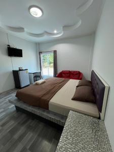 una camera con un grande letto e una televisione di Nuttida resort ณัฐธิดา รีสอร์ท a Ban Khae Taphao