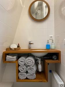 a bathroom with a sink and a pile of towels at City-beach apartment nearby Amsterdam in Hoorn