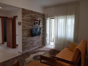 a living room with a couch and a tv on a brick wall at VI Floor Apartment in Rome