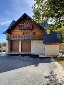 a wooden house with a balcony on top of it at Alpine House in Žabljak