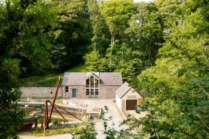 a stone house in the middle of a forest at Marina Cottage in Y Felinheli