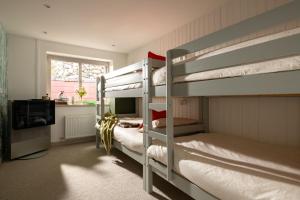 a bedroom with two bunk beds and a television at Marina Cottage in Y Felinheli