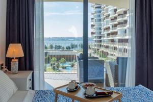 a hotel room with a bed and a view of a balcony at Golden Stones House Sea And Lake View in Istanbul