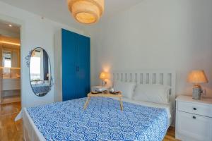 una camera da letto con un letto con copriletto blu e uno specchio di Golden Stones House Sea And Lake View a Istanbul Altre 41 foto
