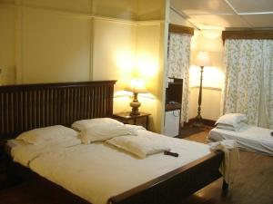 a bedroom with two beds and a lamp in it at Cafe Shillong Bed and Breakfast in Shillong