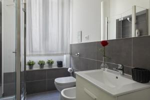 a bathroom with a sink and a toilet and a mirror at Le case di Frelli in Palermo