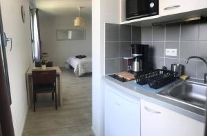 a kitchen with a sink and a counter top at Appart'Hotel - Gare TGV - Courtine - Confluence - 202 in Avignon