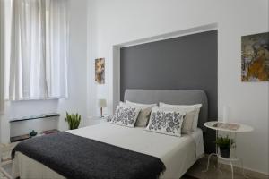 1 dormitorio con 1 cama blanca grande y 2 almohadas en Le case di Frelli, en Palermo