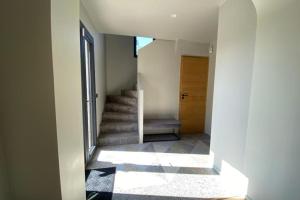 um corredor com uma escada com uma porta e uma escada em Villa Giulia - Maison avec Piscine - Bonneville-Sur-Touques em Bonneville-sur-Touques