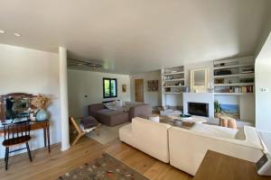 uma sala de estar com um sofá e uma mesa em Villa Giulia - Maison avec Piscine - Bonneville-Sur-Touques em Bonneville-sur-Touques