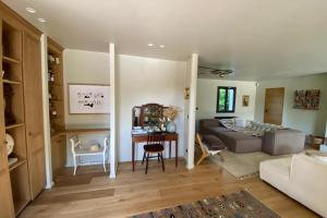 uma sala de estar com um sofá e uma mesa em Villa Giulia - Maison avec Piscine - Bonneville-Sur-Touques em Bonneville-sur-Touques