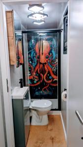 a bathroom with a toilet and a painting on the wall at Waterview - Schwimmendes Ferienhaus "Black Pearl" auf dem Wasser mit Blick zur Havel, inkl Boot zur Nutzung in Fürstenberg-Havel