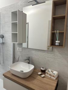 baño con lavabo blanco en una encimera de madera en Casa Marilù, en Bolonia