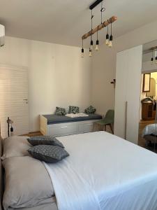 a bedroom with a large white bed with a bench at Casa Marilù in Bologna