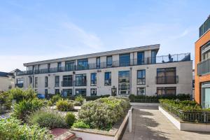 an apartment building with a garden in front of it at Luxury 2 Bedroom Penthouse In Chertsey in Chertsey