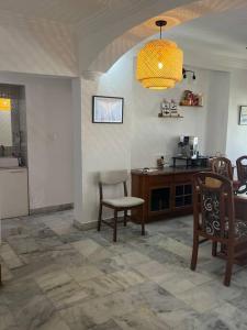 ein Wohnzimmer mit einem Tisch und Stühlen sowie eine Küche in der Unterkunft 3BHK Duplex Service Apartment near Riverfront in Ahmedabad