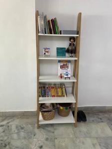 ein Bücherregal mit Büchern neben einer Wand in der Unterkunft 3BHK Duplex Service Apartment near Riverfront in Ahmedabad