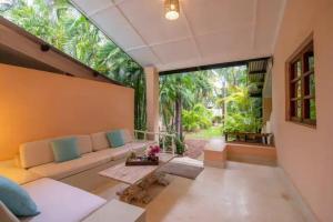 a living room with a couch and a large window at Allamanda Villa by YourHost, 10 bedroom, Malindi in Malindi
