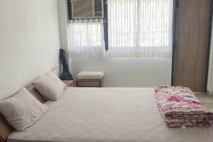 Schlafzimmer mit einem großen Bett und einem Fenster in der Unterkunft 3BHK Duplex Service Apartment near Riverfront in Ahmedabad