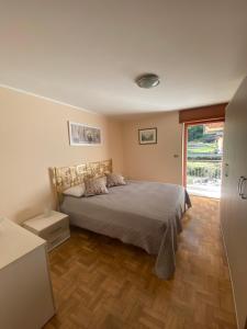 um quarto com uma cama e piso em madeira em Ca del Nore em Fontainemore